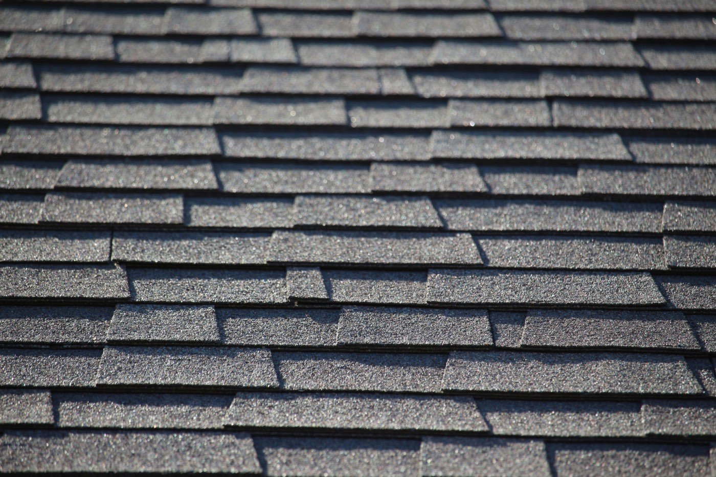 Courses of gray architectural shingle with random-width tabs and deep shadow lines